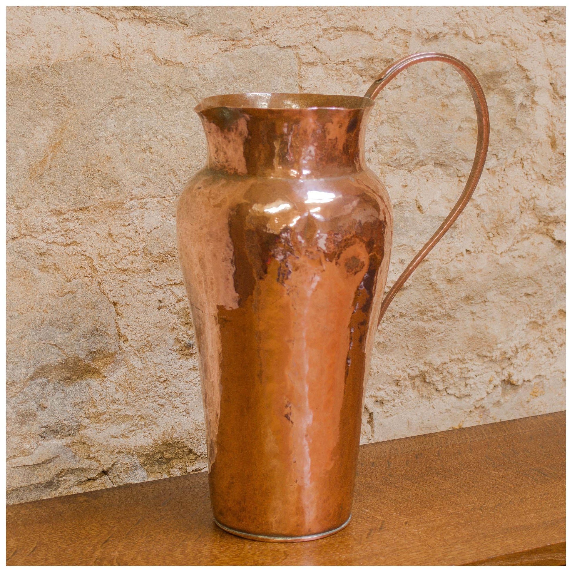 An Arts & Crafts Lakes School hand beaten copper jug by Fanny Carter