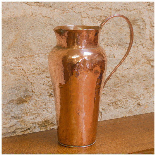 An Arts & Crafts Lakes School hand beaten copper jug by Fanny Carter